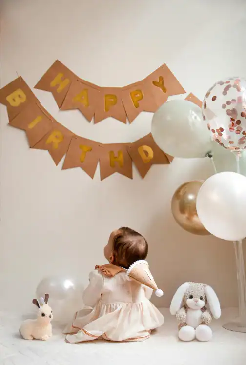 baby's staring up at birthday sign on wall