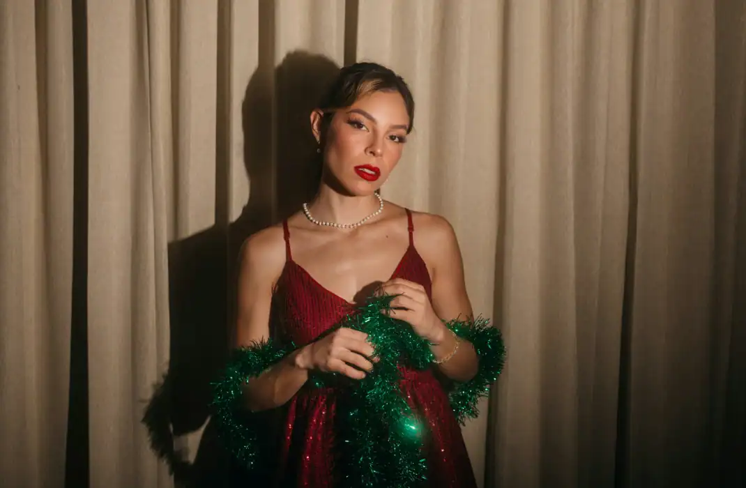 woman in sparkly red dress holding green tinsel
